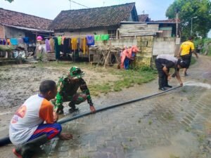 Polisi Bersama TNI dan Warga Gotong Royong Bersihkan Material Luapan Sungai Jurang Dandang di Nganjuk