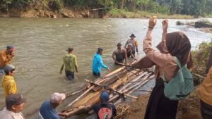 Polisi dan Warga Bantu Seberangkan Anak Sekolah di Jember Gunakan Bambu Rakit  Akibat Jembatan Putus